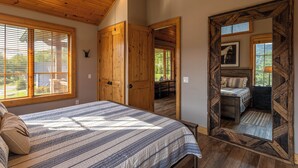 A bedroom with a large bed, wooden ceiling, and a view of a balcony. - Valley View (Banner Elk)