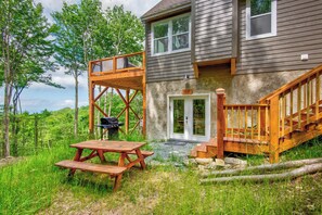 A two-story house with a deck, a barbecue grill, and a picnic table. - Lessons from Mars (Banner Elk)