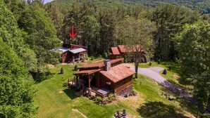 A cabin complex surrounded by dense forest, with a clear road leading to it. - Bear Woods Belle at Eagles Nest (Banner Elk)