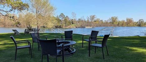 A lakeside patio with outdoor furniture and a view of the lake.
