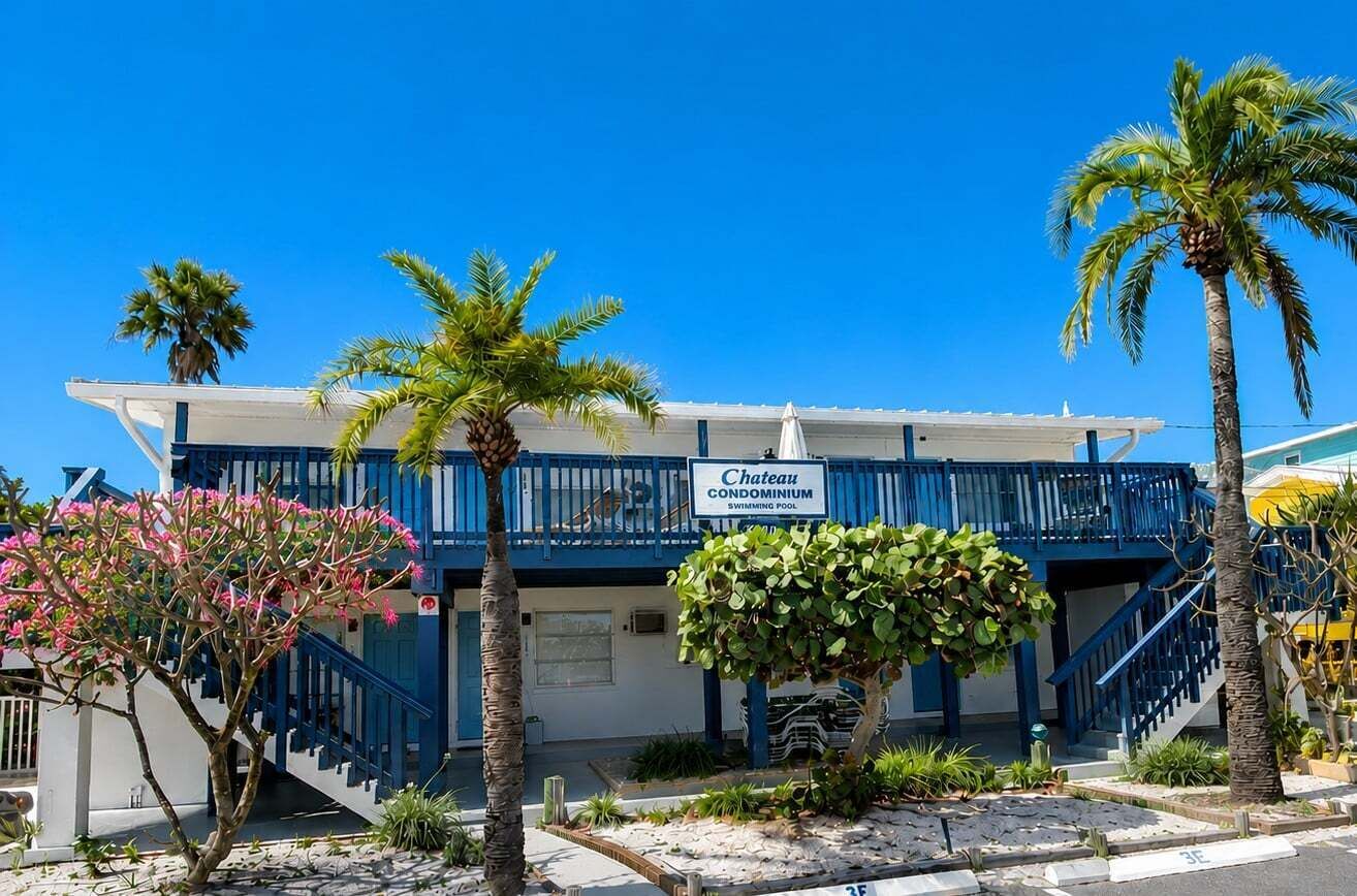 A blue building with a sign reading 'Chateau Condominium Swimming Pool.'
