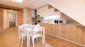 A modern kitchen with wooden cabinets, a white countertop, and a built-in microwave.