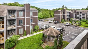 A multi-story residential building with balconies, a parking lot, and a gazebo. - Lovely Condo in Downtown Blowing Rock (Blowing Rock)