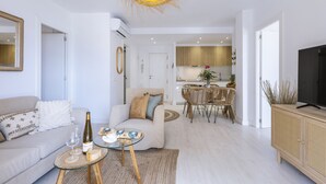 Uma sala de estar moderna com sofá, mesa de centro e área de jantar com cadeiras e mesa.