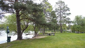 A park with a lake, picnic tables, and a bench.