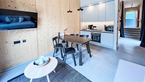 A modern kitchen with a built-in oven and a dining area with a round table and chairs.