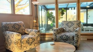 Una habitación amplia con techo alto, ventanas grandes y mobiliario con diseño.