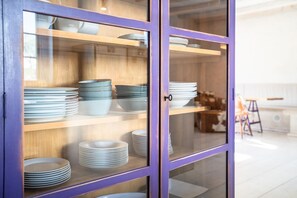 Ein gläserner Schrank mit Regalen, auf denen Teller und Schüsseln stehen.