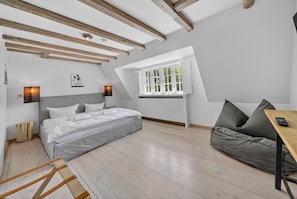 Ein Schlafzimmer mit Bett, Sofa, Tisch und Fenster.