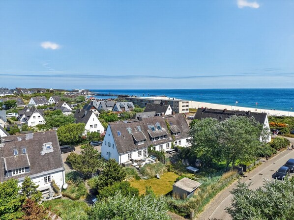 Ein Küstenwohngebiet mit Häusern, einem Strand und einer Mole.