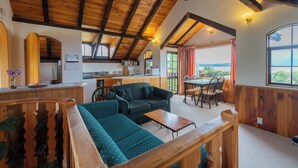 A cozy interior with a wooden ceiling, a sofa, a dining table, and a kitchen area. - Manapouri Holiday Park (Manapouri)