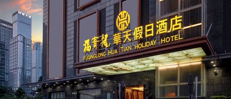A hotel with a prominent sign in both Chinese and English, indicating it is the Fuqinglong Hua Tian Holiday Hotel.