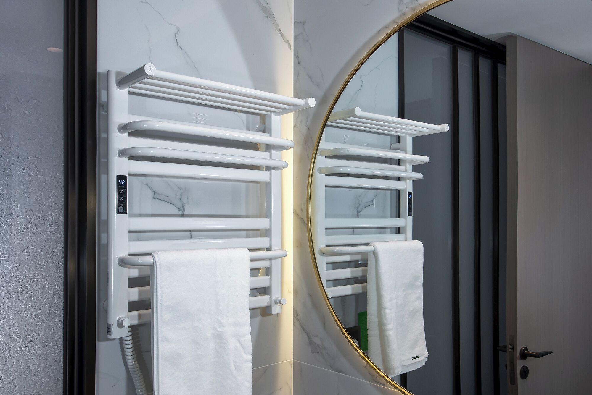 A bathroom with a white towel rack, a mirror, and a door.