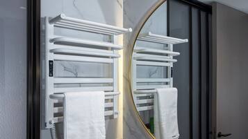 A bathroom with a white towel rack, a mirror, and a door.