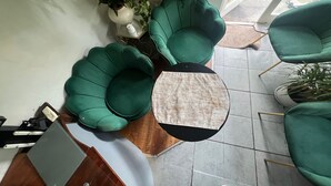 A modern living room with green armchairs, a round coffee table, and a laptop on a wooden side table. - My Sky Secret Garden Near atractions (London)