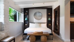Une chambre moderne avec un grand lit, un banc en bois et un élément décoratif mural.