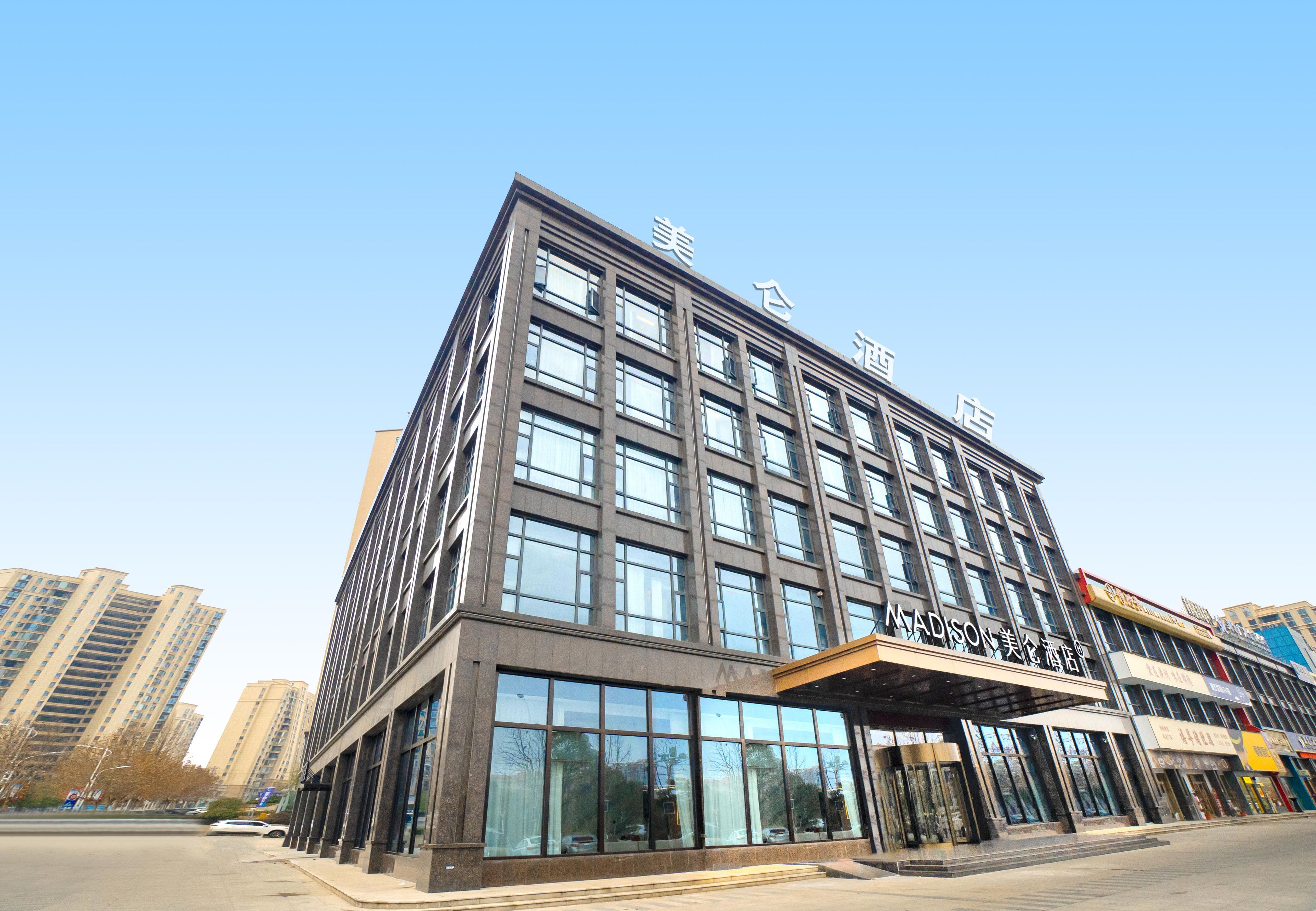 A modern hotel building with multiple floors, large windows, and a prominent entrance.