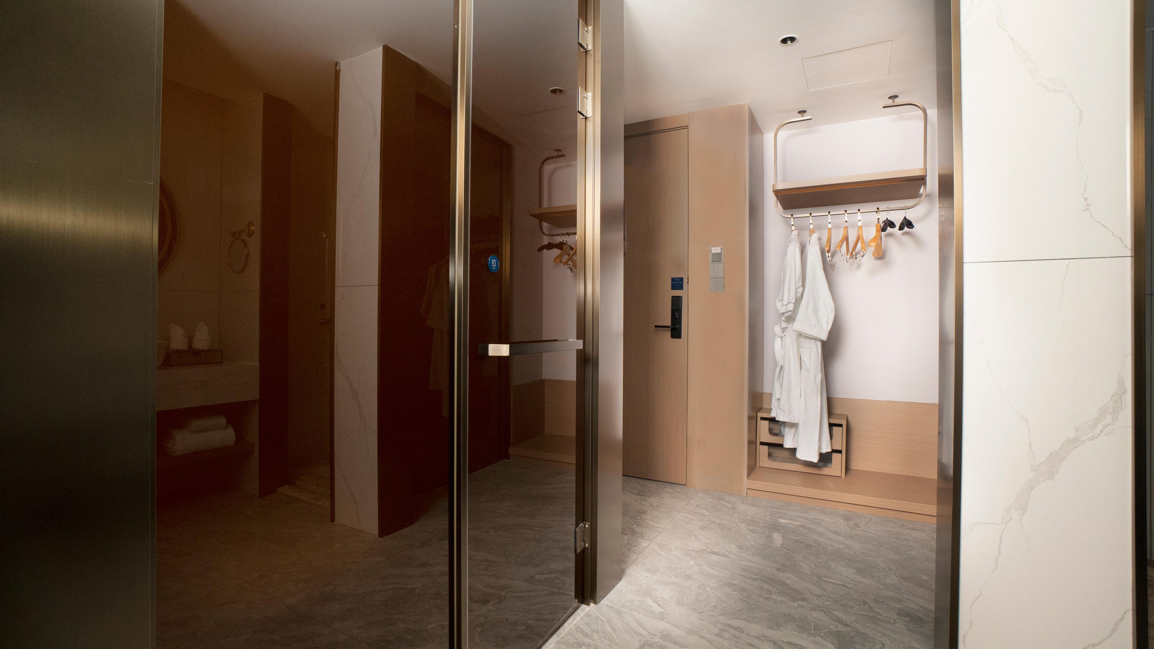 Une salle de bain moderne équipée d’une douche, d’un porte-serviettes et d’un miroir.