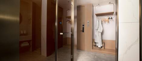 A modern bathroom with a shower, a towel rack, and a mirror.