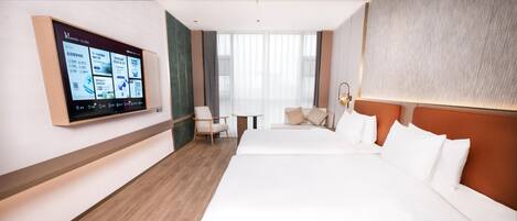 Una habitación de hotel con una cama grande, un escritorio, una silla y un televisor montado en la pared.