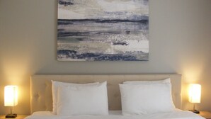 A neatly made bed with white linens and two bedside lamps on either side. - Modern Seaside Beach Retreat (Saint Helena Island)