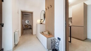 A modern hallway with a mirror, a small desk, and a radiator. - 1 bedroom beautiful apartment in Muntic (Muntic)