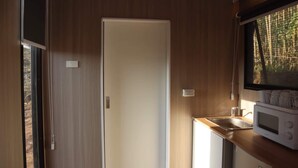 A compact kitchen with a microwave, a sink, and a door leading to an outdoor area. - Jade in the Wilderness (碧野寮) (Dahu Township)