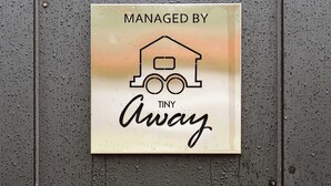 A sign with a house icon and the text "MANAGED BY TINY Away". - Jade in the Wilderness (碧野寮) (Dahu Township)