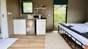 A compact room with a kitchenette, a bed, and a view of greenery. - Jade in the Wilderness (碧野寮) (Dahu Township)