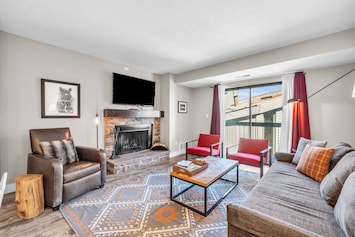 Living room: Couch w/pull out queen bed, 3 chairs, TV, wood burning fireplace, access to balcony