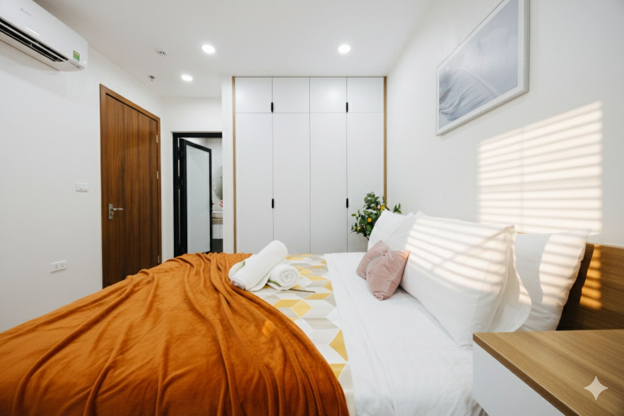 Un dormitorio con una cama, una mesita de noche de madera, una ventana con persianas y una puerta.