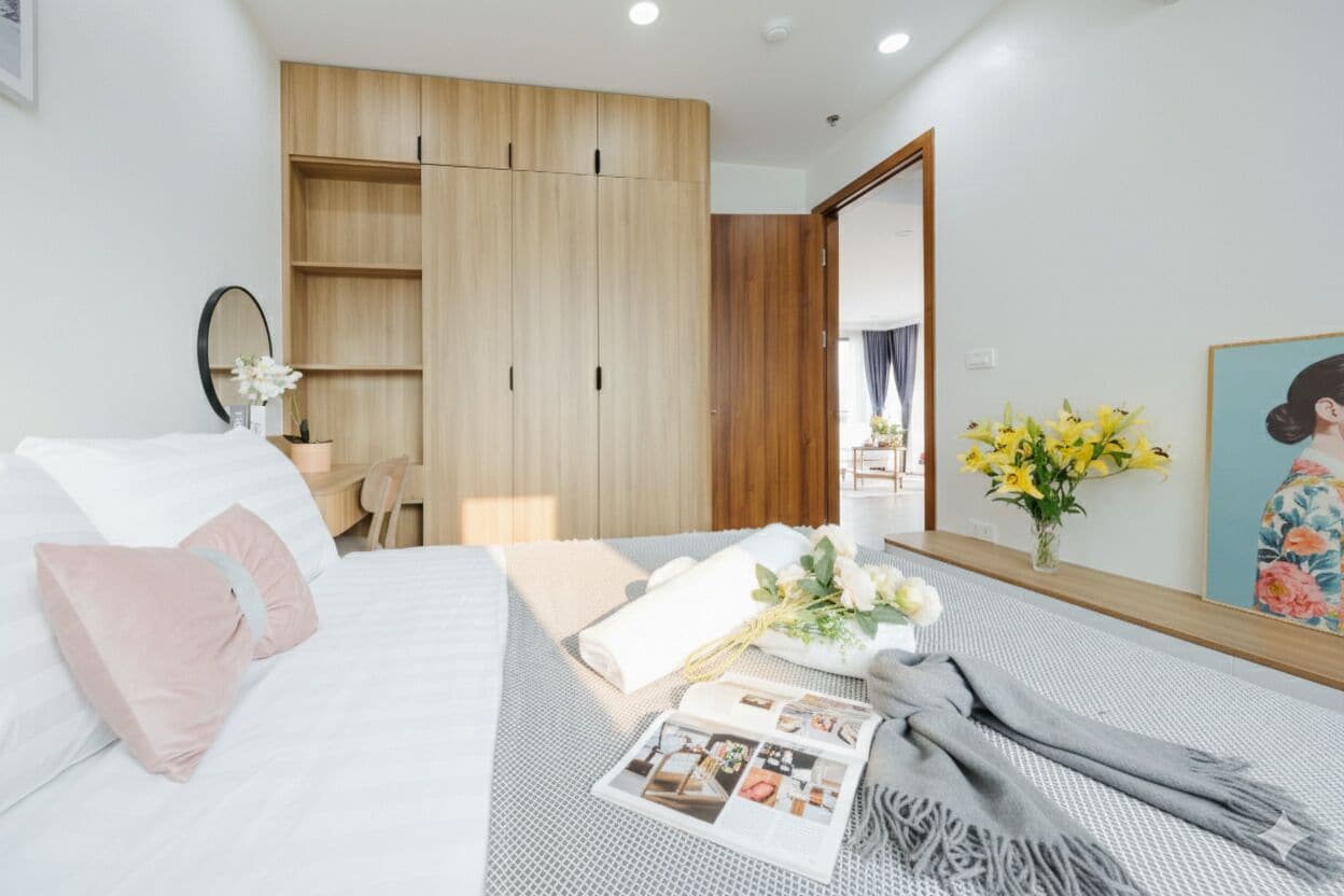 Una camera da letto moderna con un letto, un armadio in legno, uno specchio e un quadro.
