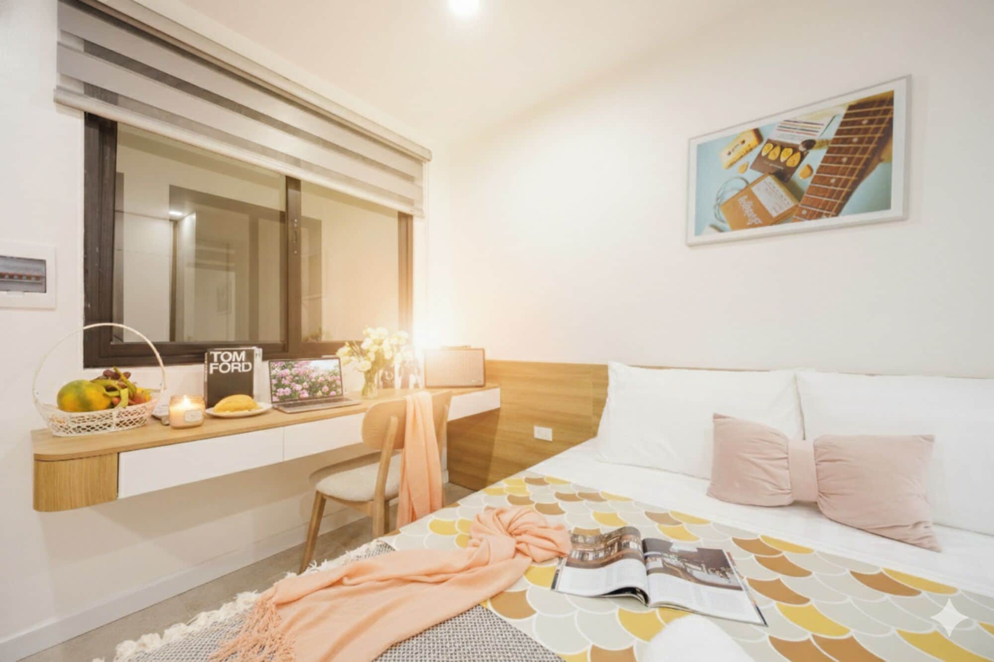 Una camera d'albergo con un letto, una scrivania con un portatile, una sedia, una finestra con persiane e un quadro appeso al muro.