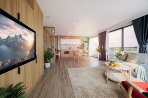 Suite Deluxe, vista lago | Area soggiorno | TV a schermo piatto 52 pollici con canali via cavo