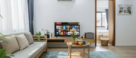A modern living room with a sofa, a coffee table, and a flat-screen TV.