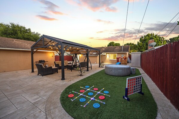 A backyard with a covered patio, outdoor seating, and a game table. - Coastal Home Near UCSB & Airport + Hot Tub, King Beds, Fast Wifi, Sleeps 6 (Goleta)
