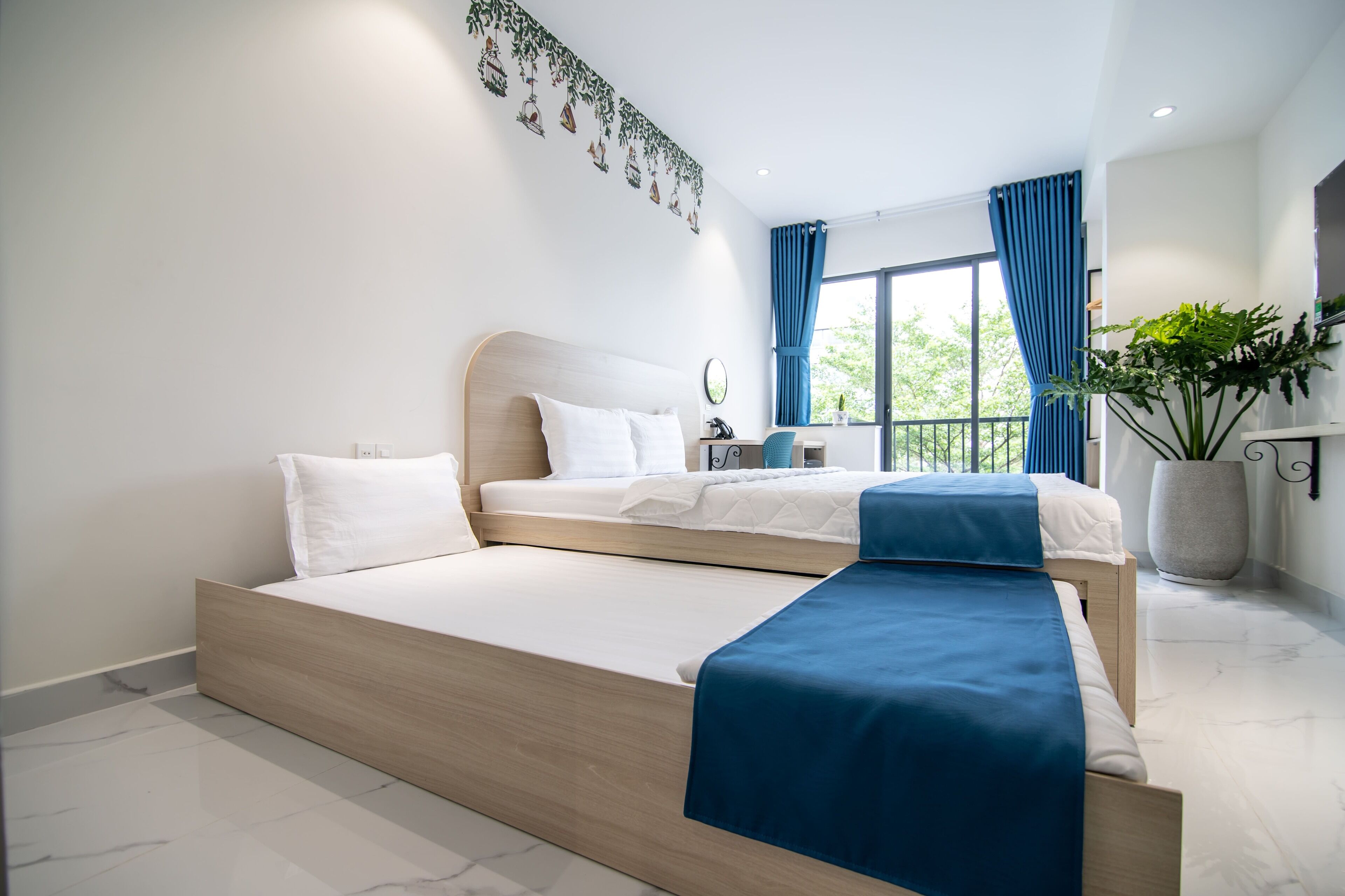 Una habitación de hotel moderna con una cama grande, un escritorio pequeño y vistas al exterior.