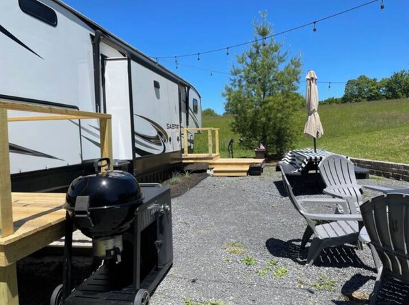 Ett fritidsfordon med en grill och en utomhusplats med sittmöbler.