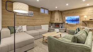 Uma sala de estar aconchegante com lareira, sofá e televisão.