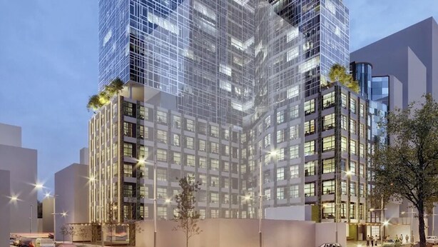Un immeuble moderne de grande hauteur, doté d’une façade en verre, de nombreux étages et d’un design original, notamment au niveau des angles.