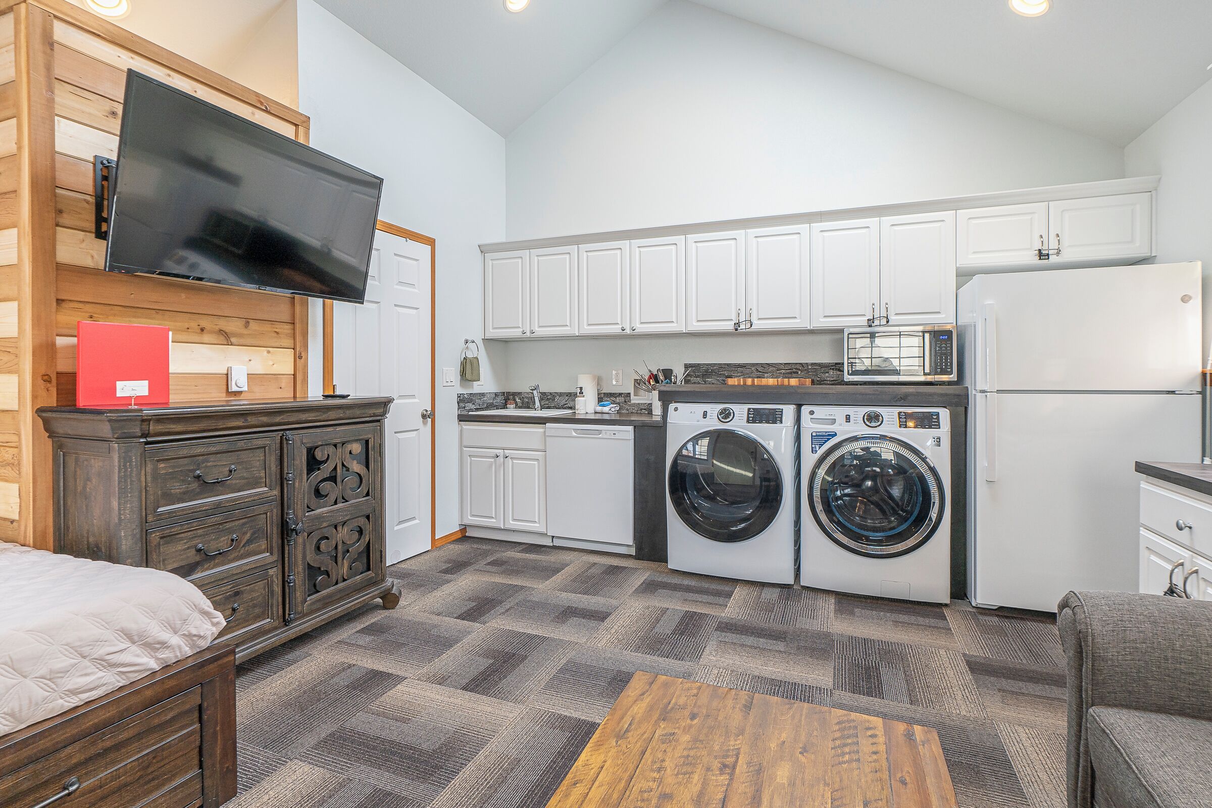A compact kitchen with a washing machine, microwave, and refrigerator.