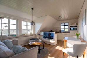 A modern loft with a living area, kitchen, and dining space.
