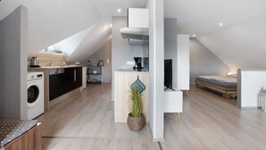 Un apartamento moderno con cocina, comedor, sala de estar y un dormitorio.