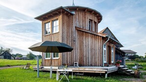 Ein Holzhaus mit einem Balkon, einem Tisch mit Stühlen und einem Blumentopf.