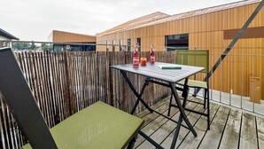 Een terras met een tafel, stoelen en waterflessen.