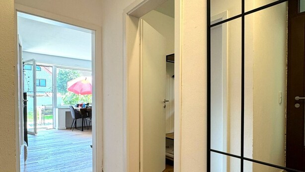 A hallway with wooden flooring, white walls, and a large mirror. - Holiday Home 'Ferienhaus Ahaus' with Private Terrace, Private Garden and Wi-Fi (Ahaus)