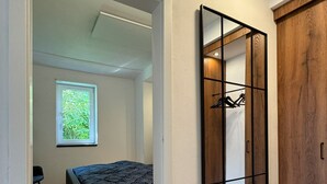 A bedroom with a bed, a window, a wardrobe, and a mirror. - Holiday Home 'Ferienhaus Ahaus' with Private Terrace, Private Garden and Wi-Fi (Ahaus)