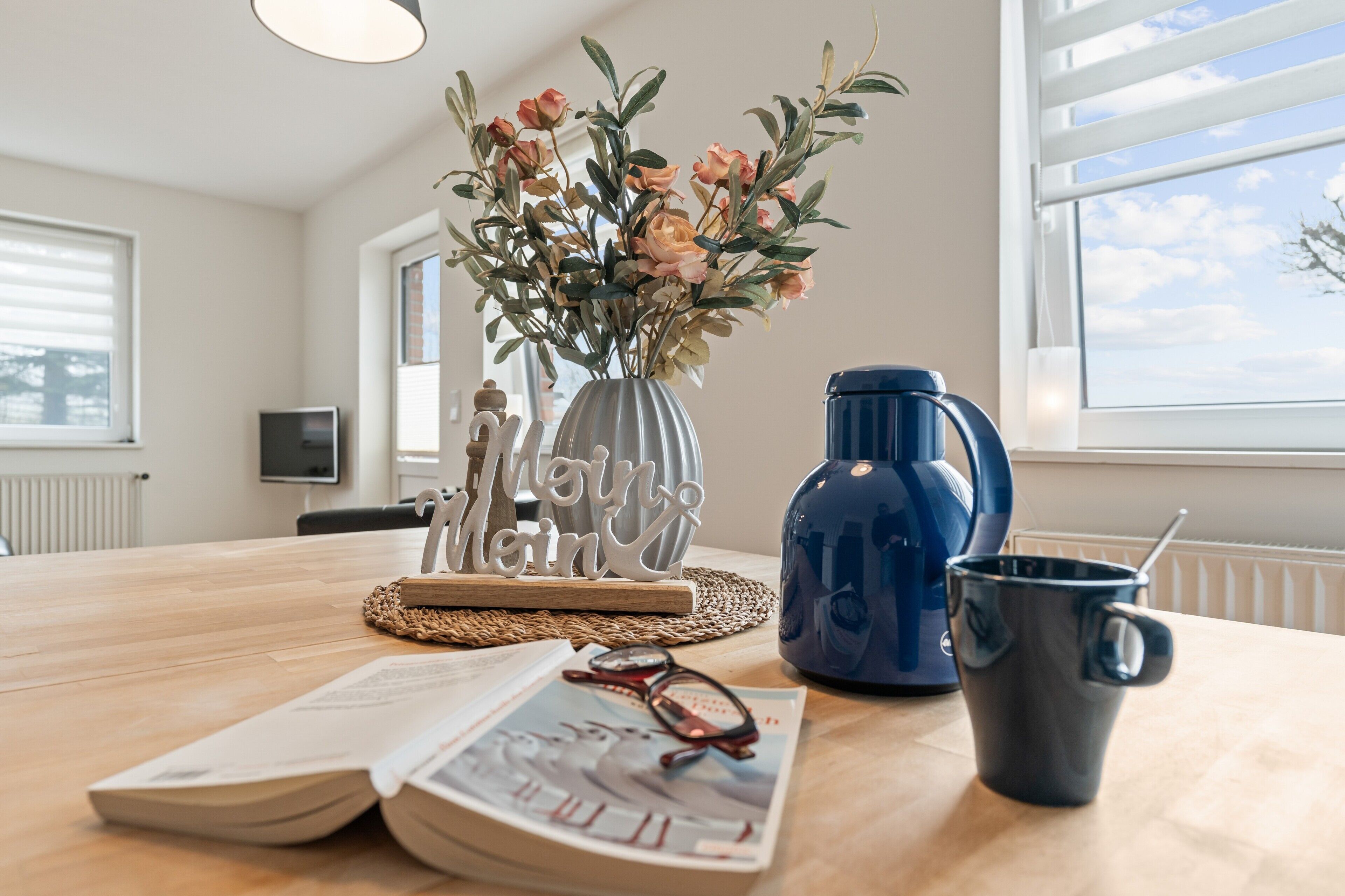 Ein Holztisch mit einer Blumenvase, einer Tasse und zwei Gläsern.