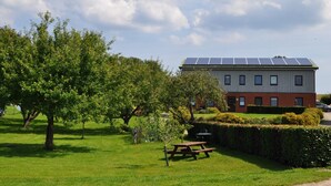 Un bâtiment doté de panneaux solaires, d’une table de pique-nique et d’une pelouse bien entretenue.