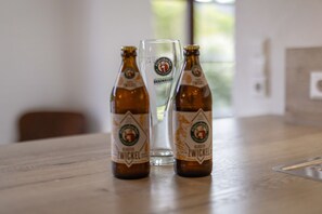 Two bottles of beer and a glass on a wooden table.